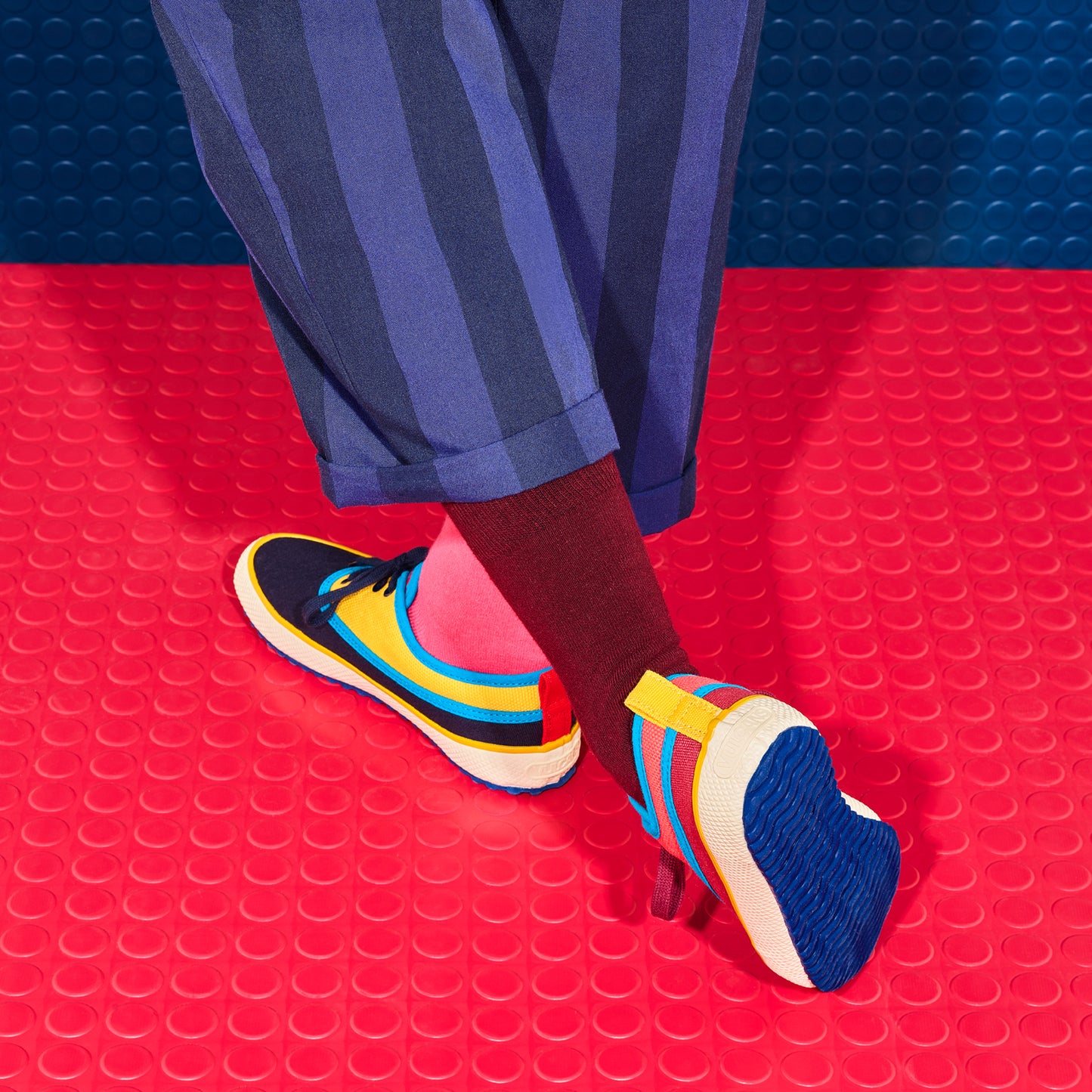Colorful Ocean shoes on a red and blue textured floor. 